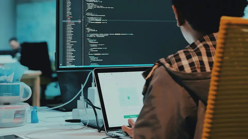 A developer at a computer workstation, representing the professional software work discussed in the article.